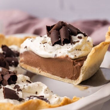 a slice of chocolate cream pie being lifted from pan.
