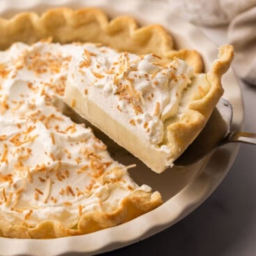 a slice of coconut cream pie coming out of the pan.