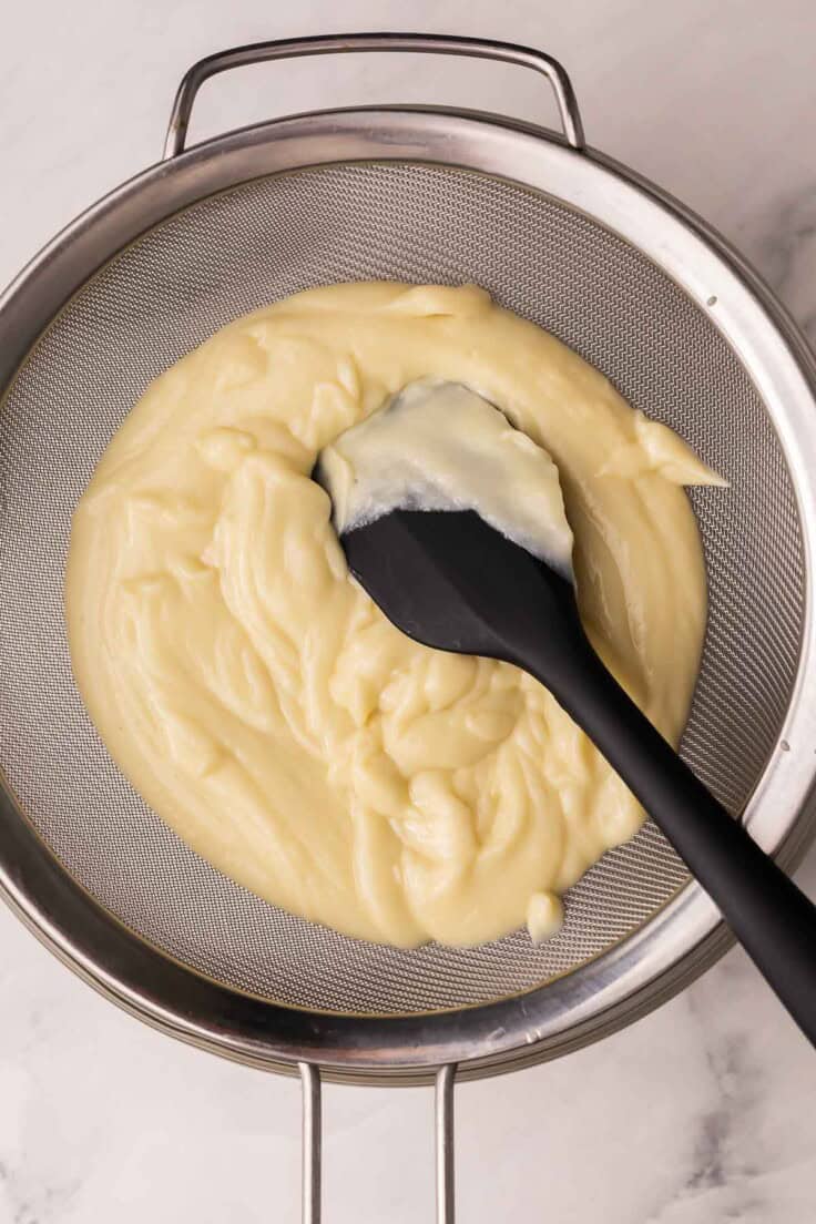 coconut cream filling in strainer with black spatula.