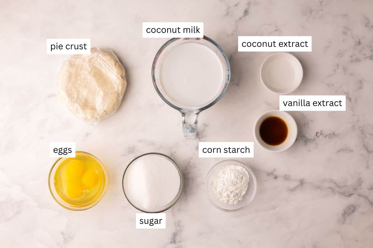 Coconut Cream Pie is a from-scratch dessert with a buttery homemade crust and thick coconut custard filling, finished with whipped cream and toasted coconut. Perfect for spring or Easter dessert! #easter #dessert #recipe | easter recipes | coconut dessert | coconut recipes | coconut pie | easter pie | homemade pie recipe | easter dessert ingredients needed for coconut cream pie in bowls.