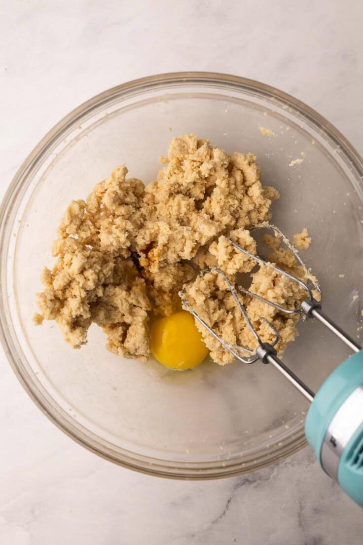 egg added to bowl of dough ingredients.