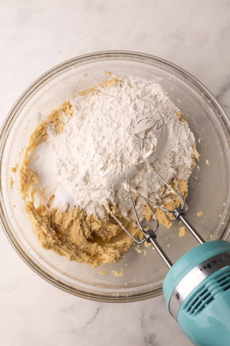 flour added to glass bowl with other ingredients.