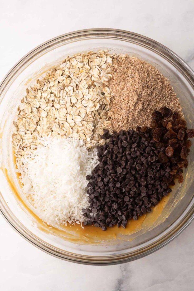unmixed granola bar ingredients in glass mixing bowl.