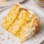 close up of a slice of pineapple coconut cake on a white plate.