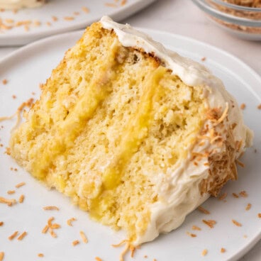 close up of a slice of pineapple coconut cake on a white plate.