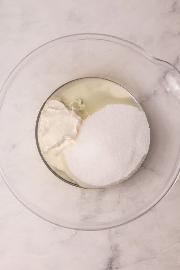 sugar and other ingredients added to glass mixing bowl.