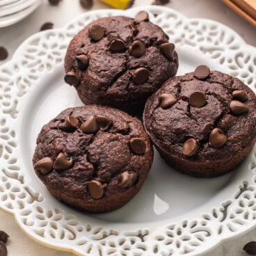 chocolate banana bran muffins on a white plate.