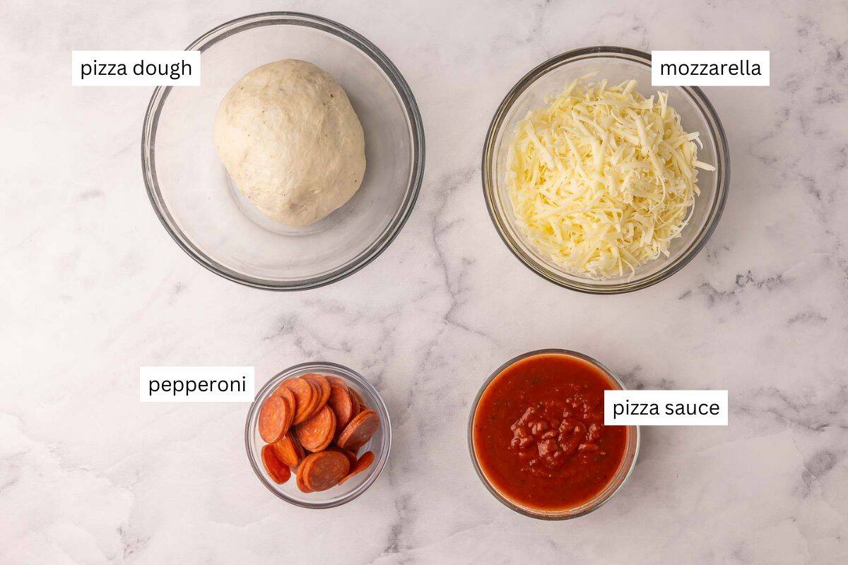 Pizza Buns are easy, cheesy handheld bites made with pizza dough, pizza sauce, shredded cheese, and pepperoni. They’re kid-friendly, portable, customizable, and great for lunches, snacks, or quick dinners! #pizza #dinner #recipe | easy recipes | pizza recipes | lunch ideas | lunches for kids | family recipes | freezer friendly | pepperoni | cheese ingredients needed for homemade pizza buns in bowls.