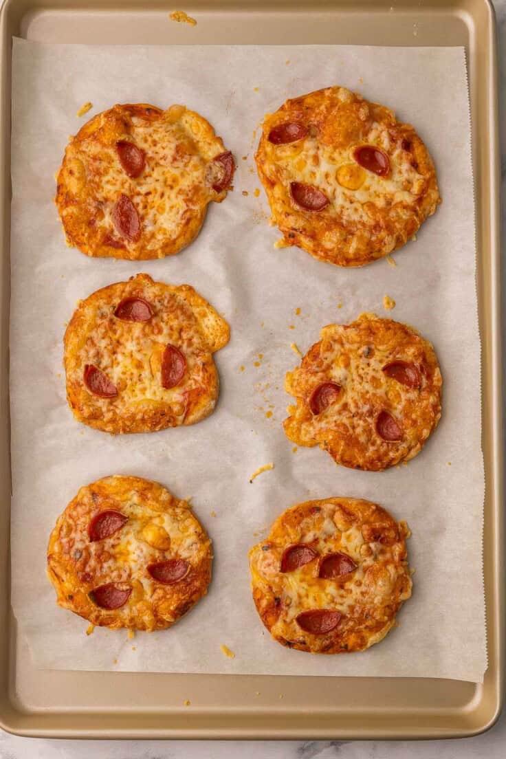 pizza buns on a parchment lined pan fresh out of the oven.