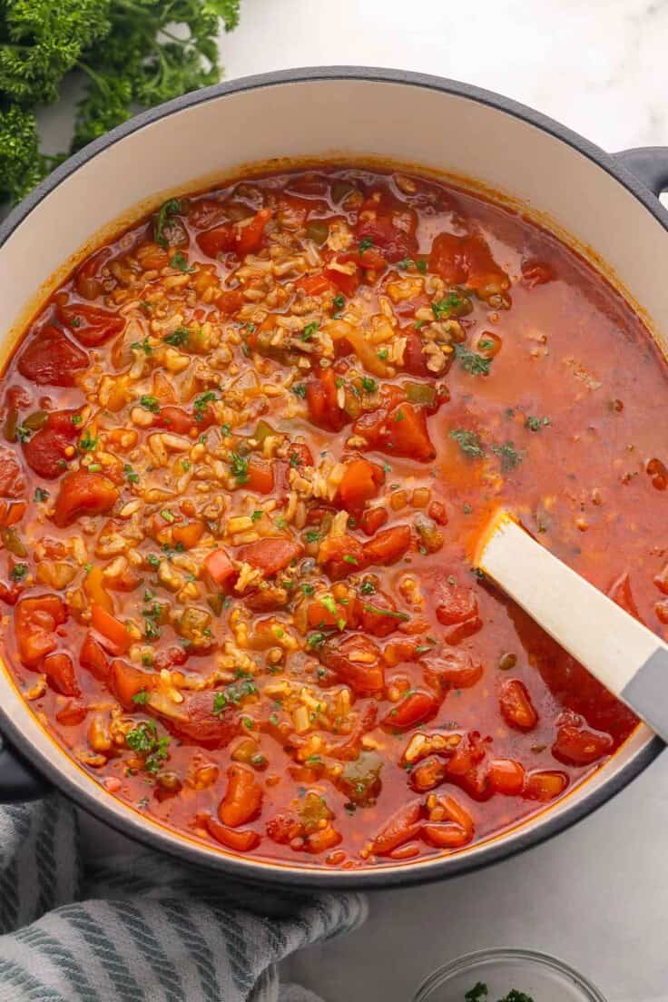 large pot of stuffed pepper soup with wooden ladle in it.