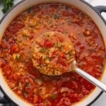 a scoop of stuffed pepper soup coming out of pot.