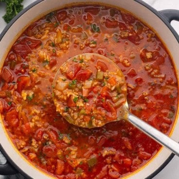 a scoop of stuffed pepper soup coming out of pot.