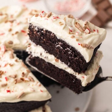 a slice of chocolate peppermint cake being lifted off platter.