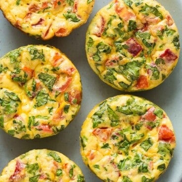 square overhead image of frittata muffins with spinach and red pepper.