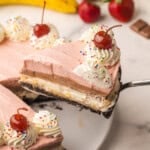 a slice of banana split cheesecake being lifted up.