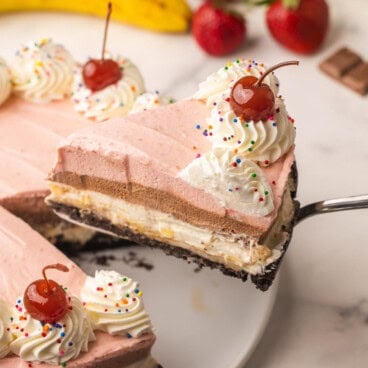 a slice of banana split cheesecake being lifted up.