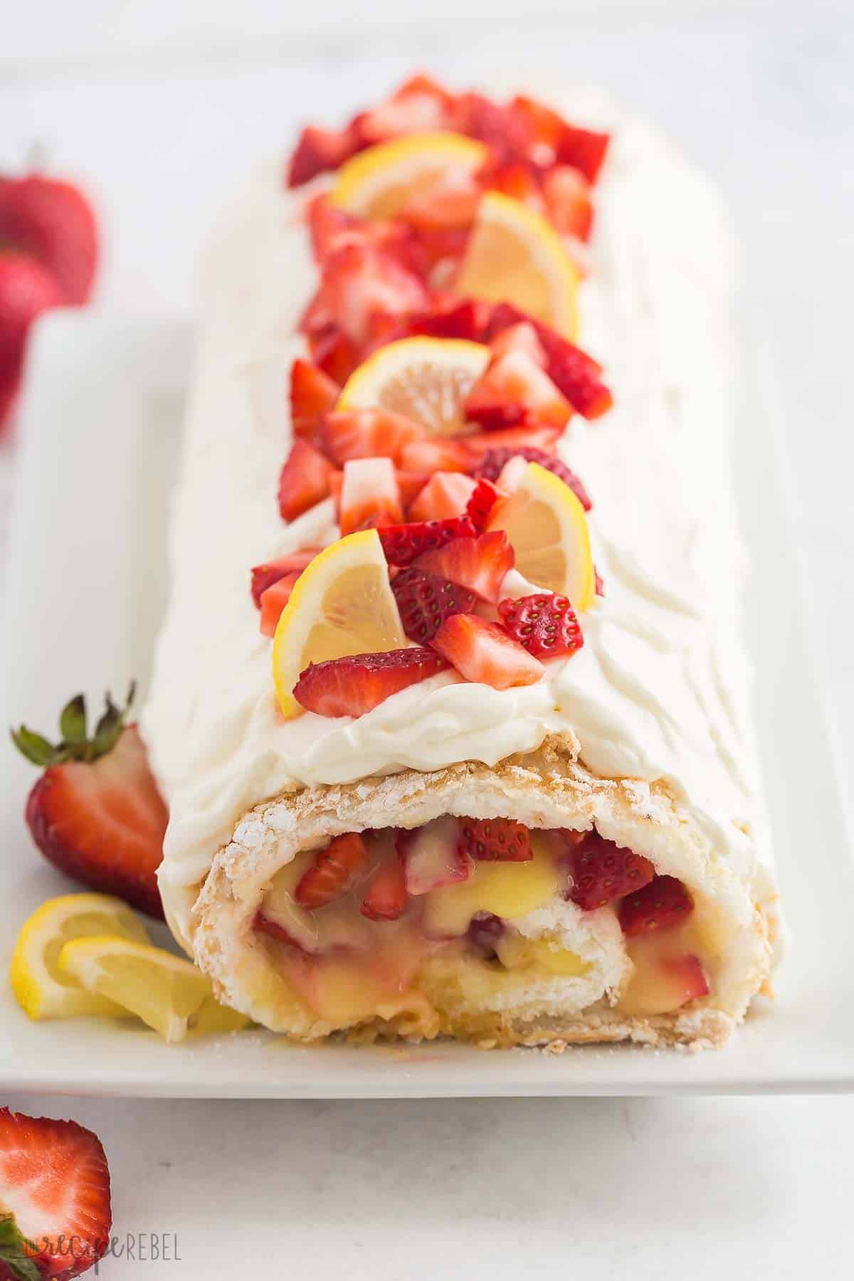 This Strawberry Lemon Angel Food Cake Roll is an easy dessert made with angel food cake mix, fresh lemon curd, and loads of fresh strawberries! The perfect easy summer dessert! #strawberry #lemon #cake #recipe #dessert | easy dessert recipes | angel food cake recipes | roll cake | summer dessert | lemon desserts | strawberry desserts | cake mix hacks strawberry lemon angel food cake roll with fresh strawberries on top.