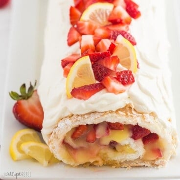 square image of strawberry lemon angel food cake roll with strawberries on top.