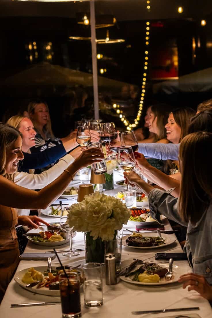 women toasting over a dinner table.