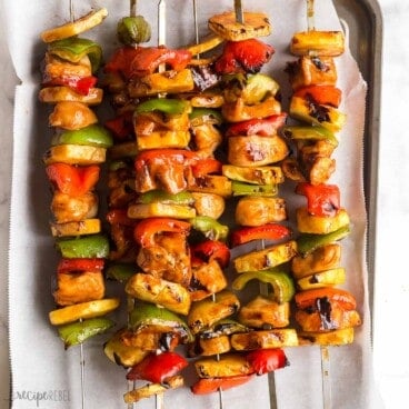 square image of hawaiian chicken kabobs on parchment lined sheet pan.
