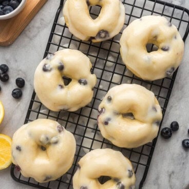square image of baked blueberry donuts on black cooling rack.