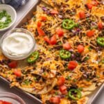 a pan of nachos topped with jalapenos.